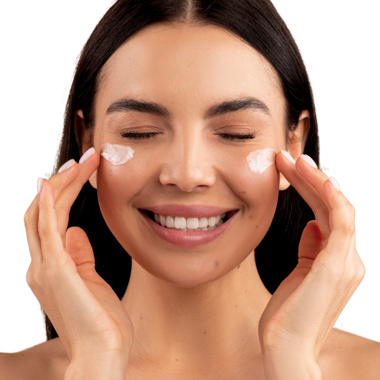 Rejuvenecimiento Facial con Tratamiento de Flacidez | Piel Firme Mujer aplicando crema facial con una sonrisa, representando el rejuvenecimiento facial con tratamiento de flacidez para una piel más firme y tonificada.